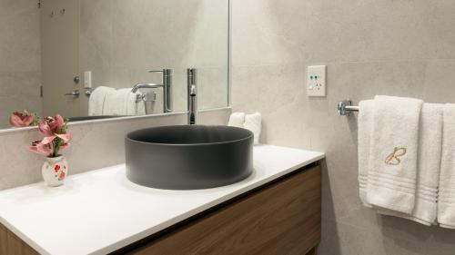 a bathroom with a black sink and a mirror at Browns Boutique Hotel in Queenstown