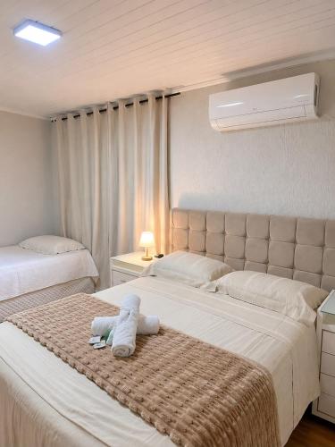 a bedroom with two beds with a stuffed animal on the bed at Quarto Privativo Próximo à BR in São José
