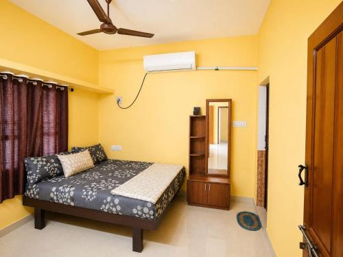 a bedroom with a bed and a ceiling fan at DilsBreak HomeStay in Kanyakumari