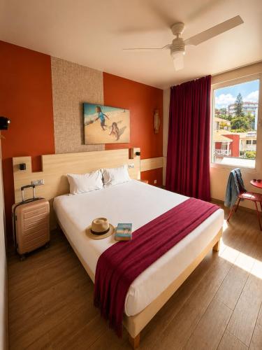 a hotel room with a large bed and a window at Gondwana City Green in Noumea