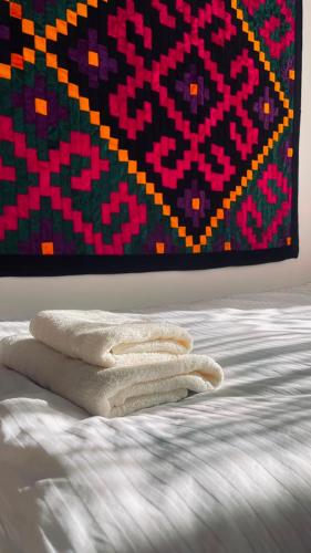 a pile of towels sitting on top of a bed at Guest house Kyial in Naryn