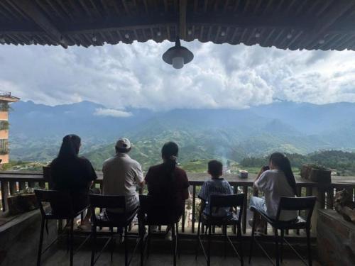 a group of people sitting at a table looking at the mountains at TIME Restaurant & Homestay Sa Pa in Sapa