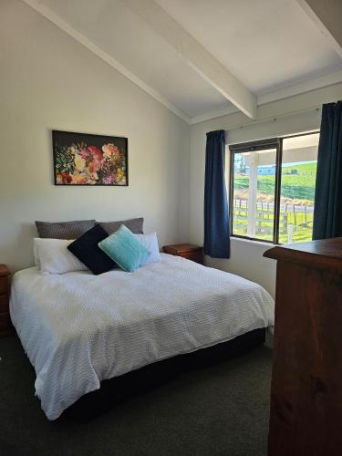 a bedroom with a large bed and a window at Rolling Hills Cottage in Tauwhare