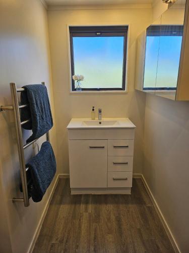 a bathroom with a sink and a window at Rolling Hills Cottage in Tauwhare
