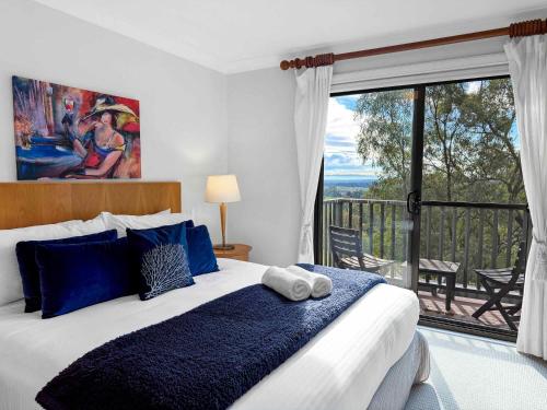 a bedroom with a large bed and a balcony at Vilamoura in Pokolbin