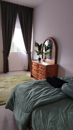 a bedroom with a bed and a dresser and a mirror at Cahaya 382 in Sitiawan