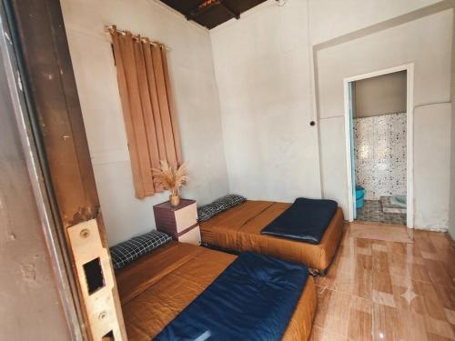 two beds sitting in a room with a window at Hajeka Family 1 in Palayangan