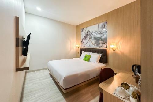 a hotel room with a bed and a desk at Urbanview Hotel Get Inn Pollux Batam in Batam Center