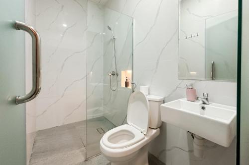 a white bathroom with a toilet and a sink at Urbanview Hotel Get Inn Pollux Batam in Batam Center