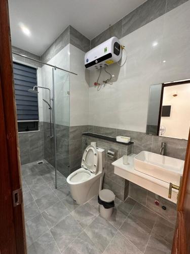 a bathroom with a toilet and a sink and a shower at House 1994 in Xuan An