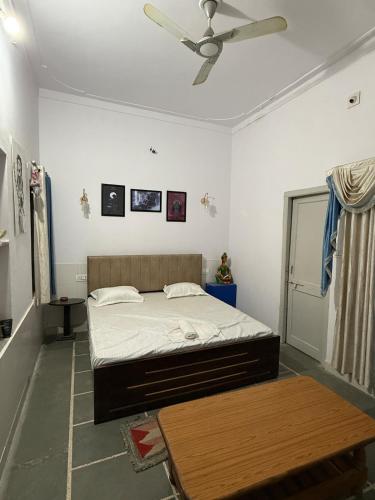 a bedroom with a bed and a ceiling fan at Ajay Niwas in Udaipur