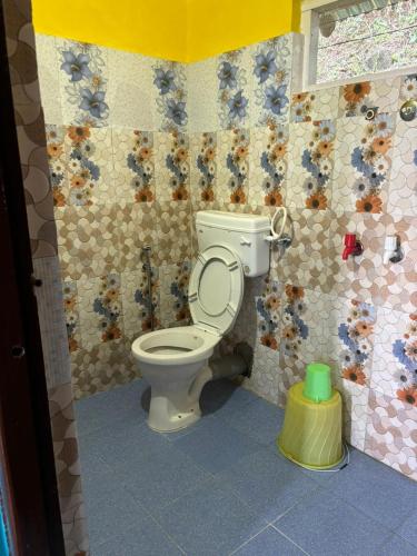 a bathroom with a toilet in a lego room at Sumikshas Homestay in Pedong