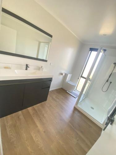 a bathroom with a sink and a mirror at Springhill at The Beach in Karikari Peninsula