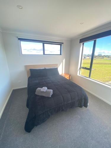 a bedroom with a bed and a large window at Springhill at The Beach in Karikari Peninsula