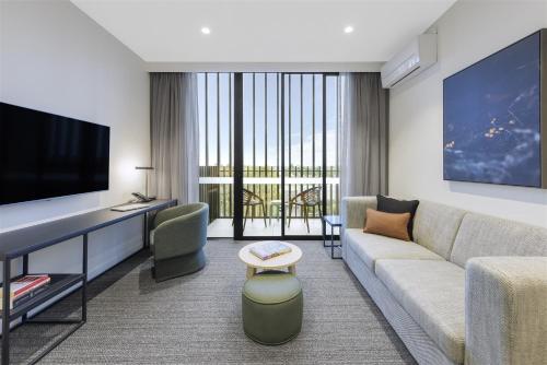 a living room with a couch and a tv at Quest Watergardens in Taylors Lakes