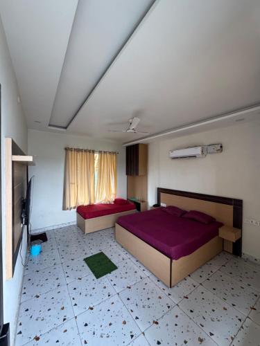ein Schlafzimmer mit zwei Betten und einem Fernseher in der Unterkunft Crystael Hotel in Babarpur