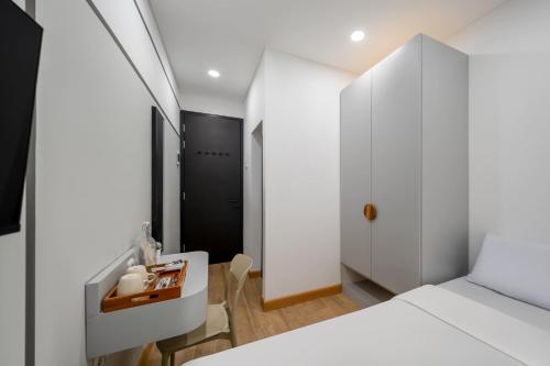 a bedroom with a white bed and a table and chairs at Cove Atman in Jakarta