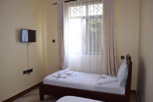 a bedroom with two beds and a window at Nyerere Green Lodge in Kwangwazi