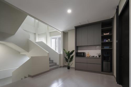 a living room with white walls and a staircase at Cove Atman in Jakarta