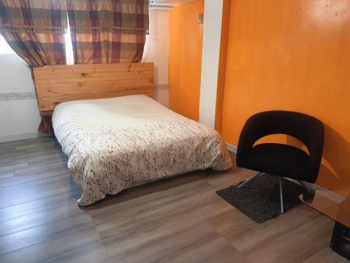 a small bedroom with a bed and a chair at Surrey central house in Surrey
