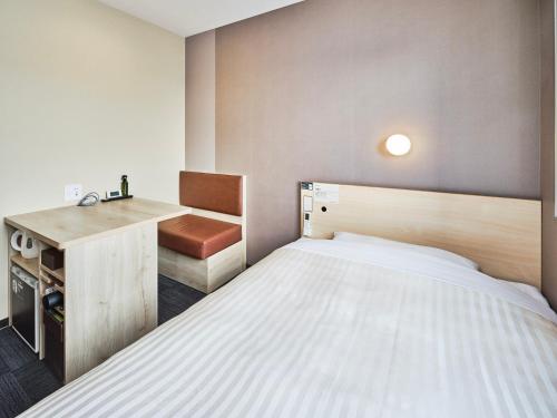 a small room with a bed and a desk at Super Hotel Kadoma in Kadoma