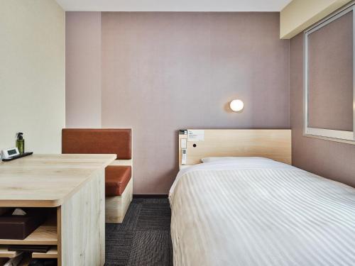 a small room with a bed and a desk at Super Hotel Kadoma in Kadoma