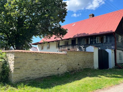 a house with a red roof and a stone wall at Chalupa Hubina in Snědovice