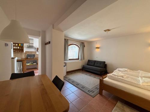 a kitchen and living room with a table and a couch at Apartment Erlah in Rateče