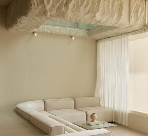 a living room with a white couch and a window at Fira Uluwatu in Uluwatu