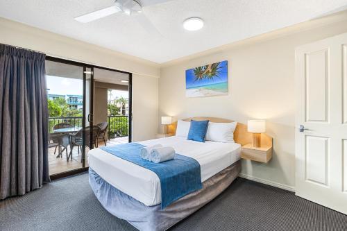 a bedroom with a bed and a balcony at Belaire Place Motel Apartments in Caloundra