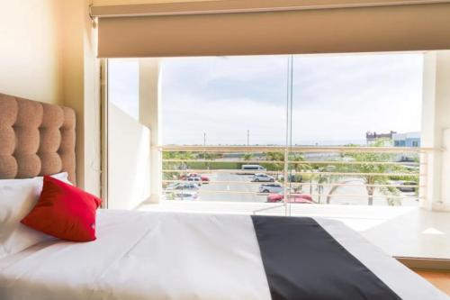 a bedroom with a bed and a large window at OYO Seoul Garden Apodaca in Monterrey