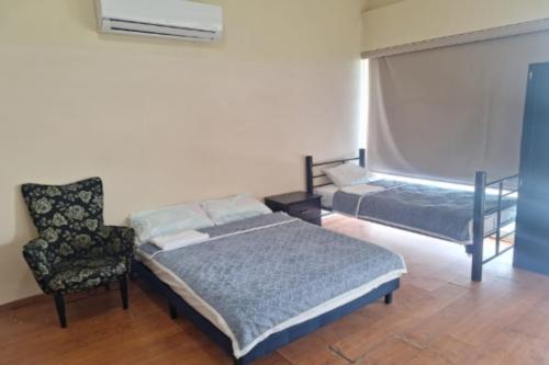 a bedroom with a bed and a chair at OYO Seoul Garden Apodaca in Monterrey