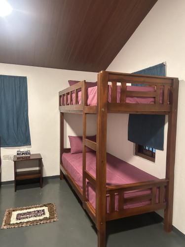 a bedroom with two bunk beds with pink sheets at Kora Beach House & Restaurant Cafe in Ampara