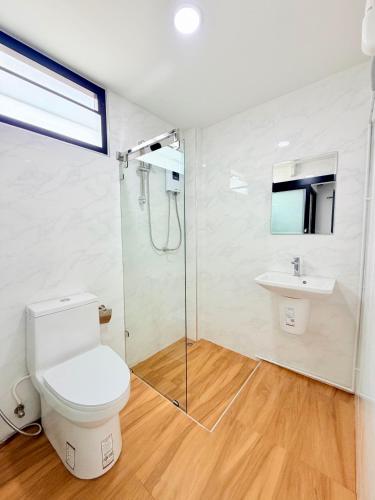 a bathroom with a toilet and a shower and a sink at ยูพี โคซี่ in Nakhon Nayok