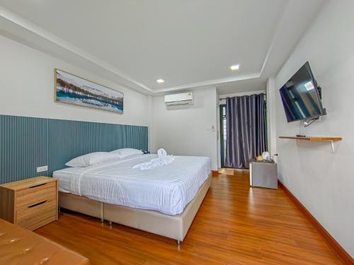a bedroom with a bed and a flat screen tv at ยูพี โคซี่ in Nakhon Nayok