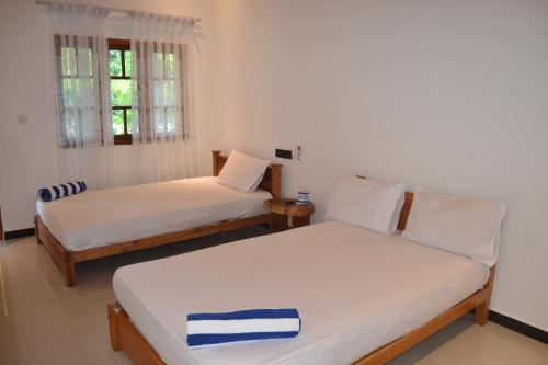 a room with two beds and a window at Nilaveli Shan Guest in Trincomalee