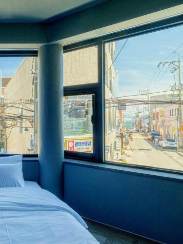 a bedroom with a view of a street from a window at ONUA Gwangalli in Busan