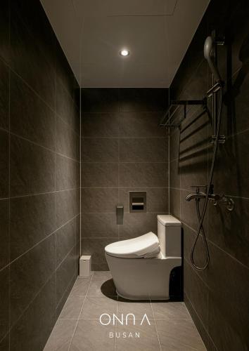 a bathroom with a tub and a toilet in it at ONUA Gwangalli in Busan