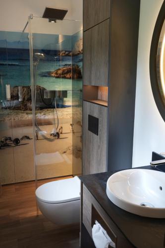 a bathroom with a sink and a toilet and a shower at Hotel Simonshof in Wolfsburg