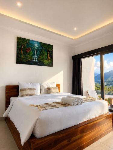 a bedroom with a large bed and a large window at Bukit Pinggan Kintamani in Baturaja