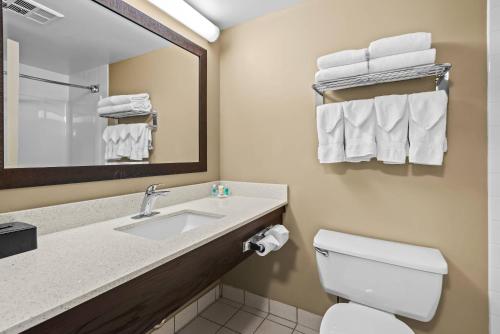 a bathroom with a sink and a toilet and towels at Comfort Inn & Suites Airport South in Calgary