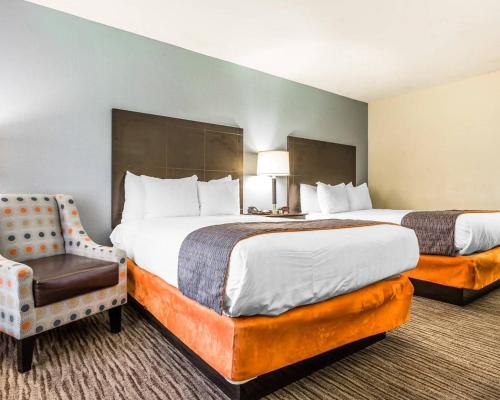 a hotel room with two beds and a chair at Quality Inn Mt Pleasant - Charleston in Charleston