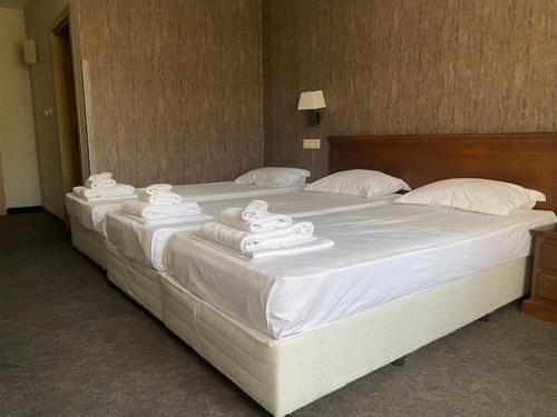 a large white bed with white towels on it at Hotel Domenic FREE PARKING in Plovdiv