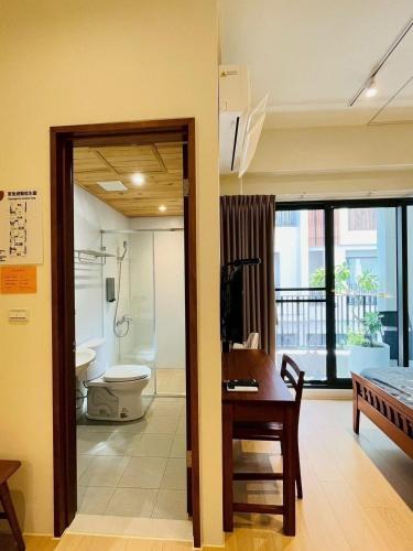 a room with a bathroom with a toilet and a table at 喜滿家民宿 in Zhuqi