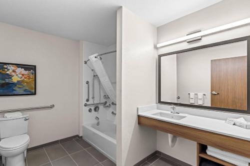 a bathroom with a sink and a toilet and a mirror at Everhome Suites Temecula Wine Country in Temecula