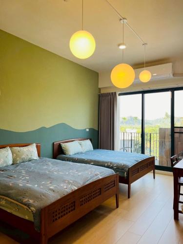 a bedroom with two beds and a balcony at 喜滿家民宿 in Zhuqi