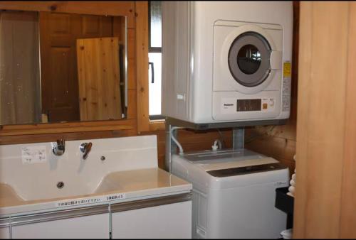 a kitchen with a sink and a washing machine at Alpine Chalets Hakuba in Hakuba