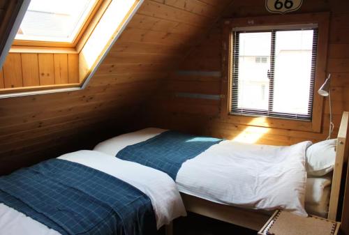 a bedroom with a bed in a wooden cabin at Alpine Chalets Hakuba in Hakuba
