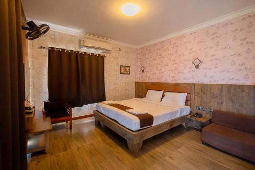 ein Schlafzimmer mit einem Bett und einer Couch in der Unterkunft Krish Garden in Chidambaram
