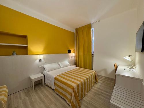 a hotel room with a bed and a yellow wall at Camere LAURO ROSSI in Macerata